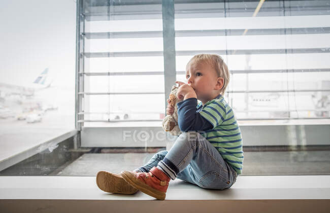 Junge sitzt neben Fenster — Stockfoto