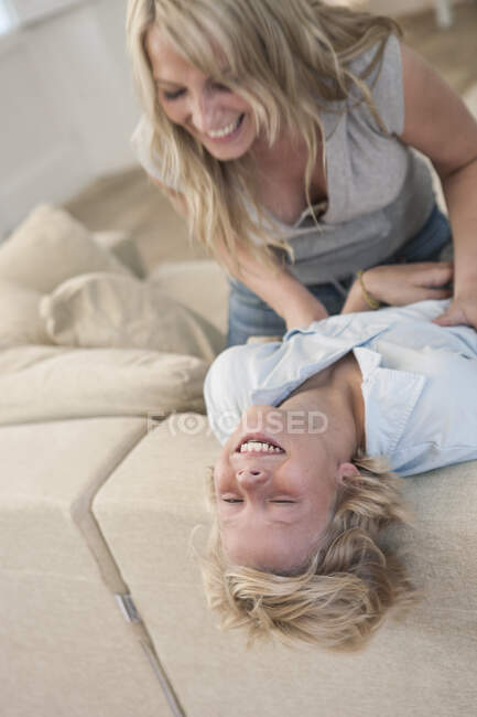 Мать щекочет смеющегося сына — стоковое фото