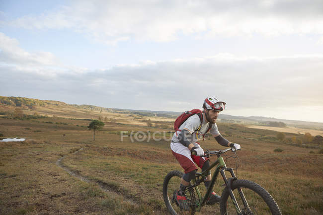 Mountain biker riding up on moorland track — Stock Photo