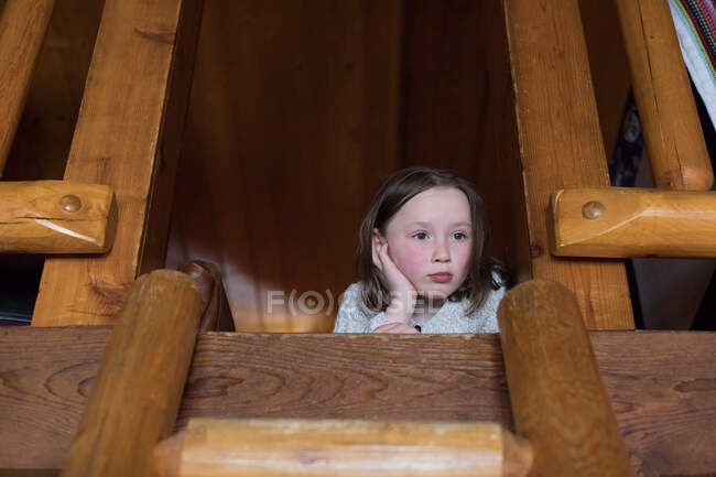 Menina deitada no chão do sótão se sentindo entediada — Fotografia de Stock