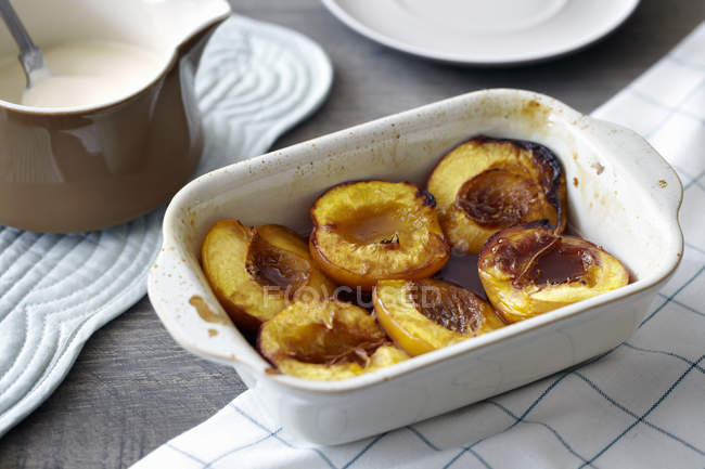 Baked nectarines in white dish, close-up — Stock Photo