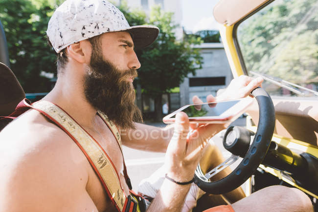 Jovem homem no carro usando navegação smartphone, Como, Lombardia, Itália — Fotografia de Stock