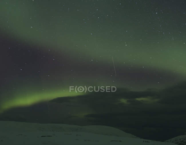 Aurora boreal é sobre a paisagem coberta de neve à noite, Finnmark, Noruega — Fotografia de Stock