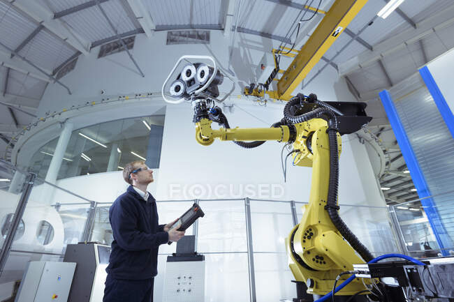 Інженер з роботом у дослідницькому центрі робототехніки, з низьким кутом зору — стокове фото