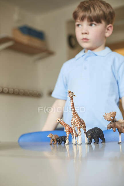 Écolier avec des animaux jouets en classe à l'école primaire — Photo de stock