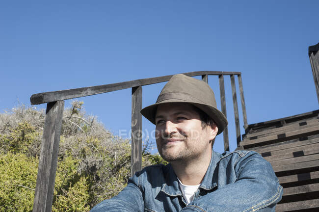 Happy mid adult man in trilby on wooden stairway at coast, Cape Town, Western Cape, Afrique du Sud — Photo de stock