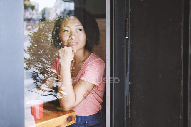 Жінка дивлячись через кафе вікна, Шанхай Французької концесії, Шанхай, Китай — стокове фото