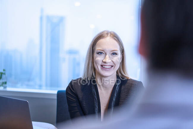 Empresária olhando colega sorrindo — Fotografia de Stock