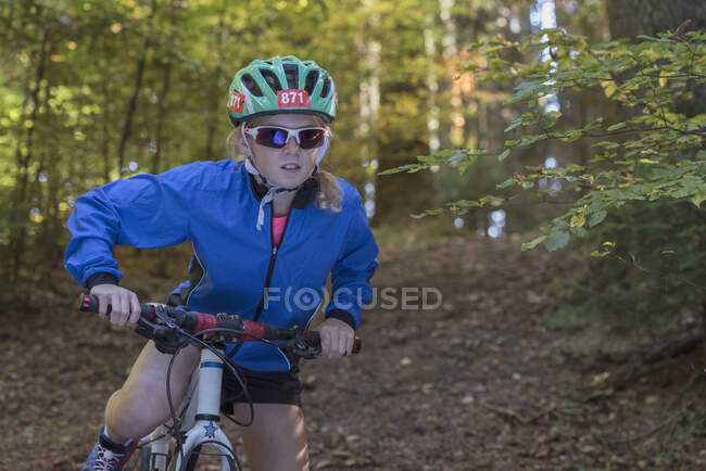 Fille VTT se préparant à faire du vélo dans les bois — Photo de stock