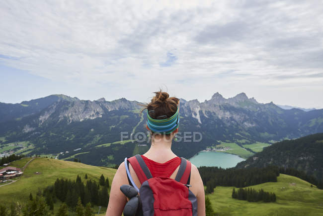 Visão traseira do caminhante feminino olhando para o vale nas montanhas de Tannheim, Tirol, Áustria — Fotografia de Stock