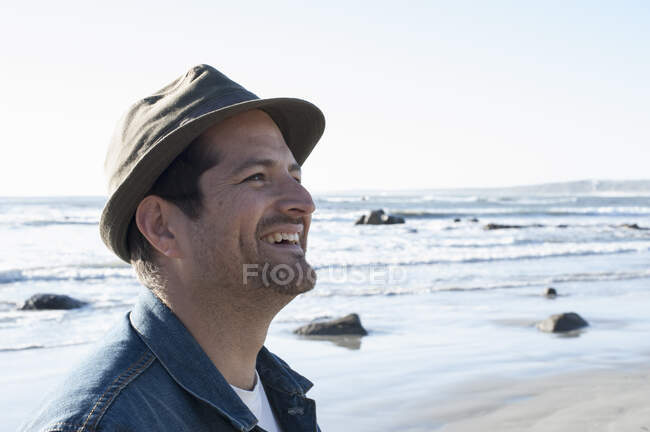 Щасливий середньодорослий чоловік у триніті на пляжі (Кейптаун, Західна Кейптаун, ПАР). — стокове фото