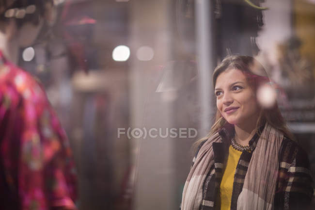 Donna che guarda e sorride alla vetrina — Foto stock