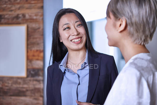 Жінка дивиться на колегу посміхається — стокове фото