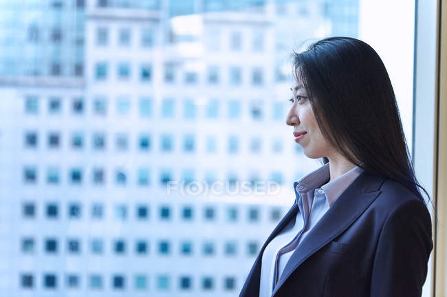 Портрет деловой женщины, выглядывающей в окно — стоковое фото