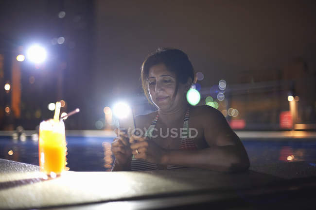 Woman in swimming pool photographing cocktail, Bangkok, Krung Thep, Thailand, Asia — Stock Photo