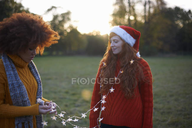 Due giovani donne in ambiente rurale con luci fatate — Foto stock