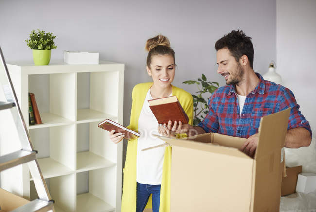 Young couple packing belongings in cardboard box — Stock Photo