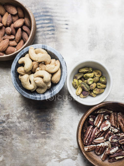 Top view of different nuts in bowls on table — Stock Photo