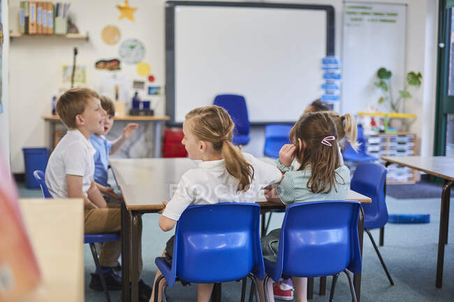Escolas e meninos em torno da mesa de aula escola primária — Fotografia de Stock