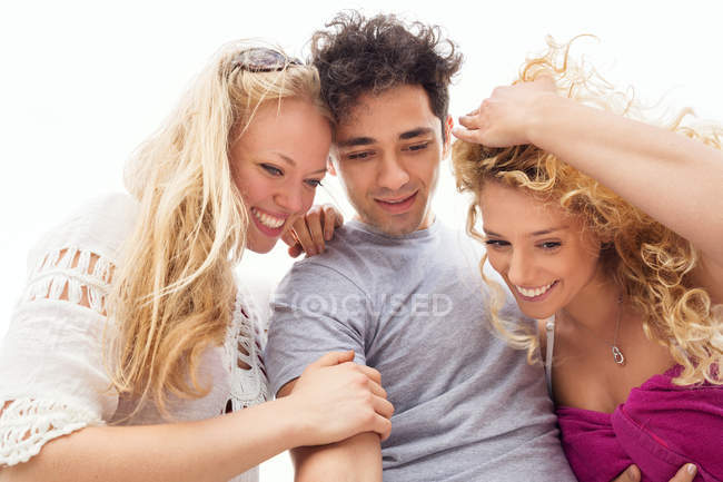 Friends huddled together smiling, looking down — Stock Photo
