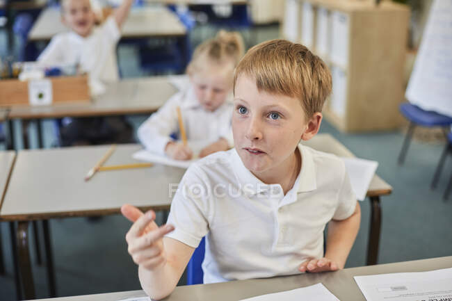 Schoolboy counting with fingers in classroom at primary school — Stock Photo