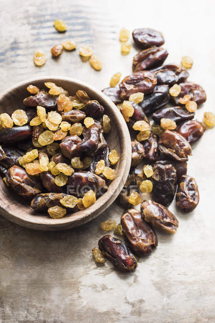 Top view of Dried dates and yellow raisin in bowl on table in kitchen — Stock Photo