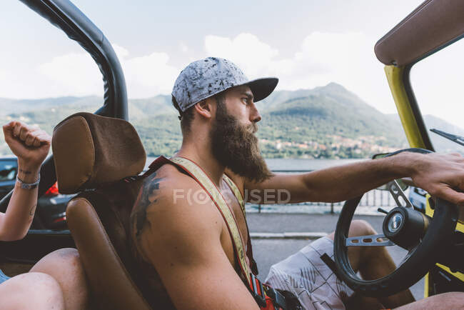 Jovem hipster macho dirigindo off road vehicle em viagem, Como, Lombardia, Itália — Fotografia de Stock
