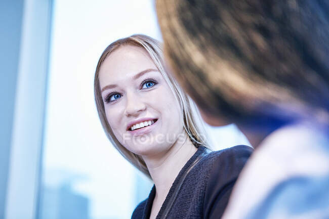 Жінка дивиться на колегу посміхається — стокове фото
