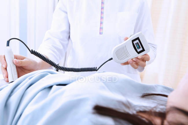 Сонограф проводит ультразвуковое сканирование беременных пациентов — стоковое фото