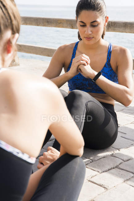 Two young women training together on sea waterfront — Stock Photo
