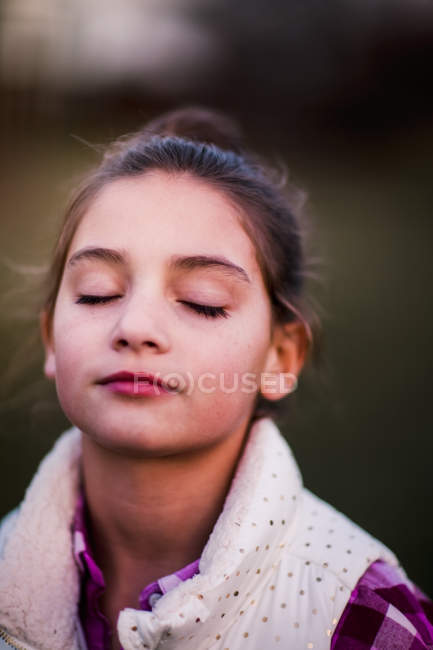 Retrato de chica con los ojos cerrados al aire libre - foto de stock
