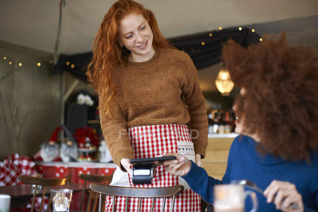 Customer making contactless payment with mobile phone in cafe — Stock Photo
