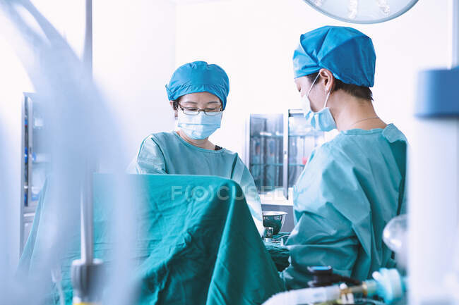 Cirujanos que realizan cirugía en quirófano de maternidad - foto de stock
