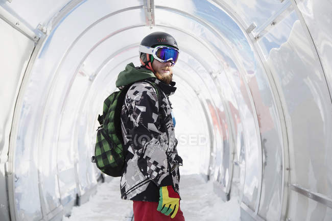 Retrato de snowboarder com mochila em pé no túnel — Fotografia de Stock