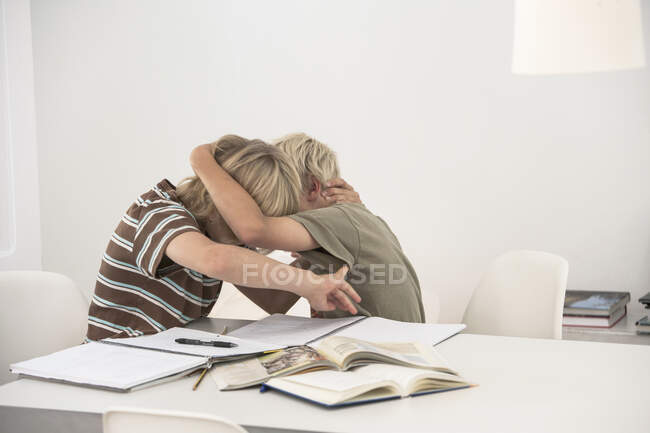 Brothers doing homework, play fighting — Stock Photo