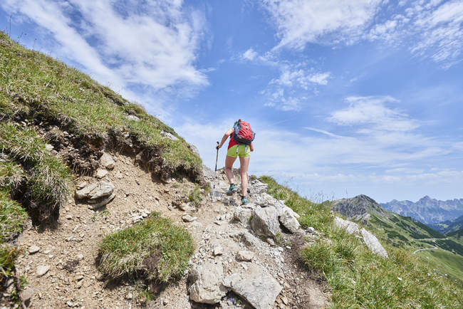 Vue arrière d'une randonneuse qui monte dans les montagnes de Tannheim, Tyrol, Autriche — Photo de stock