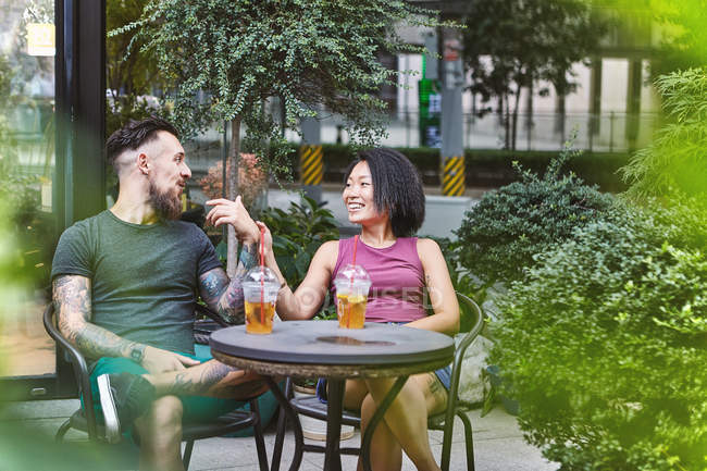 Multi pareja hipster étnica hablando en la acera cafetería, Shanghai Concesión francesa, Shanghai, China - foto de stock