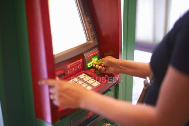 Обрезанный вид женщины, снимающей деньги с банкомата — стоковое фото