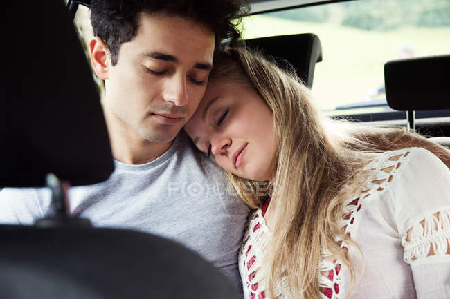 Couple in backseat of car sleeping — Stock Photo