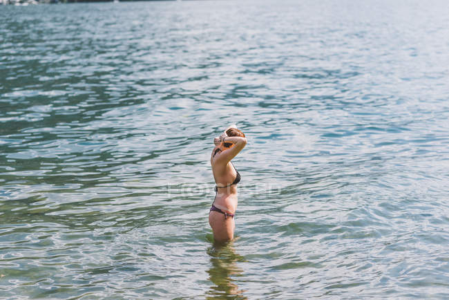 Молода жінка в бікіні коліно глибоко в регіоні Lake Como, Ломбардія, Італія — стокове фото