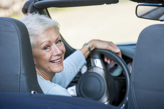 Ritratto di donna anziana in auto decappottabile — Foto stock