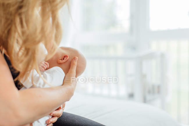 Young woman breast feeding baby daughter — Stock Photo