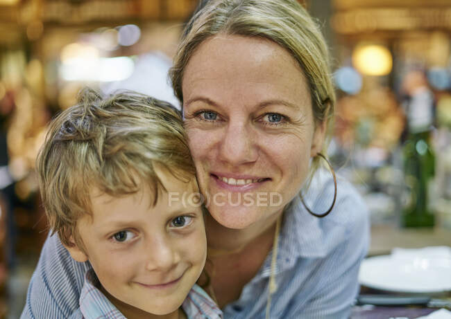 Retrato de madre e hijo mirando a la cámara sonriendo - foto de stock