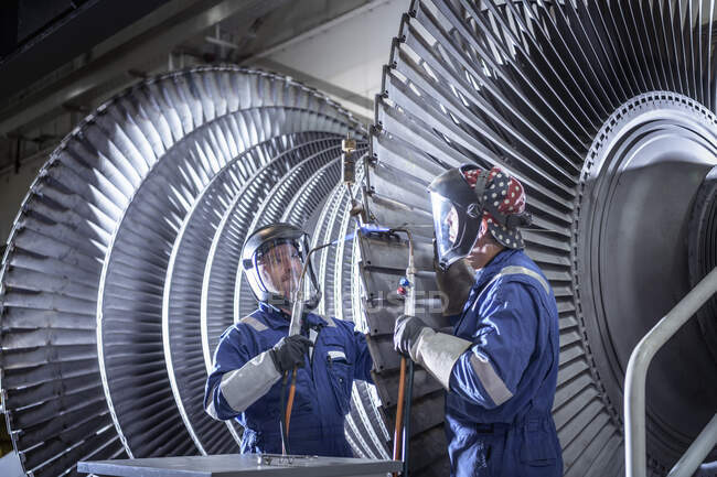 Engineers brazing ends of blades on low pressure steam turbine in turbine maintenance factory — Stock Photo
