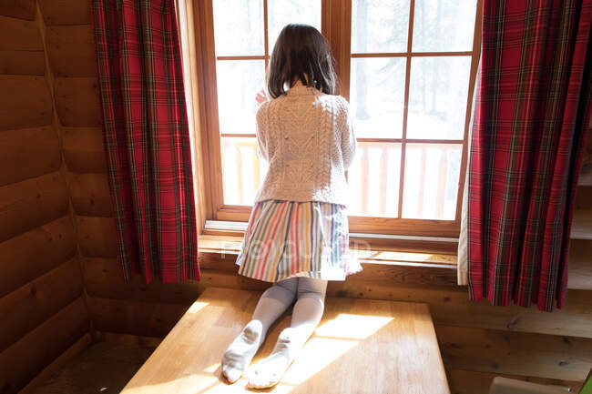 Mädchen kniet am Fenster — Stockfoto