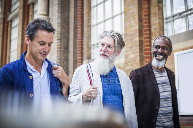 Three mature men at train station, walking together — Stock Photo