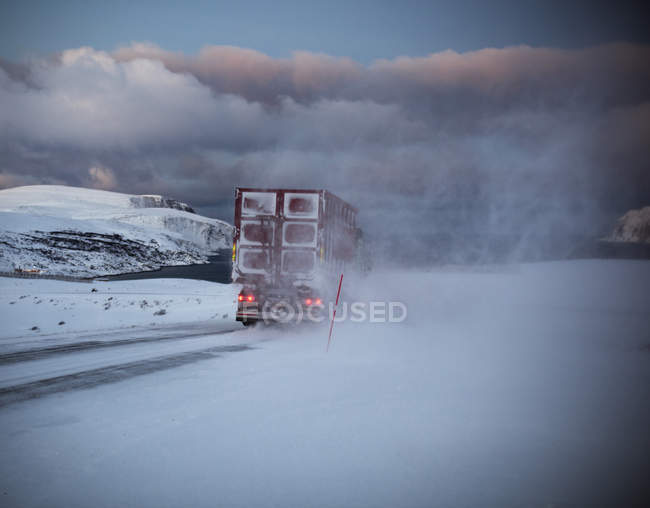 Rear view of truck driving snow covered coastal road, Finnmark, Norway — Stock Photo