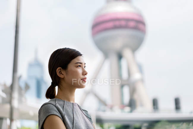 Молодая бизнесвумен смотрит в сторону финансового центра Шанхая, Китай — стоковое фото
