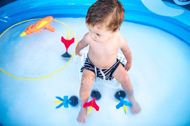 Дитячий хлопчик сидить у веслувальному басейні — стокове фото