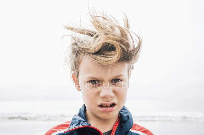 Retrato de niño con el pelo desordenado en la playa - foto de stock
